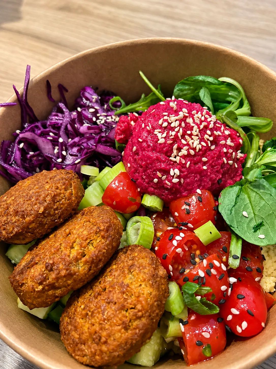 Bowl mit Falafel, Rote-Bete-Hummus, Tomaten und Rotkohl