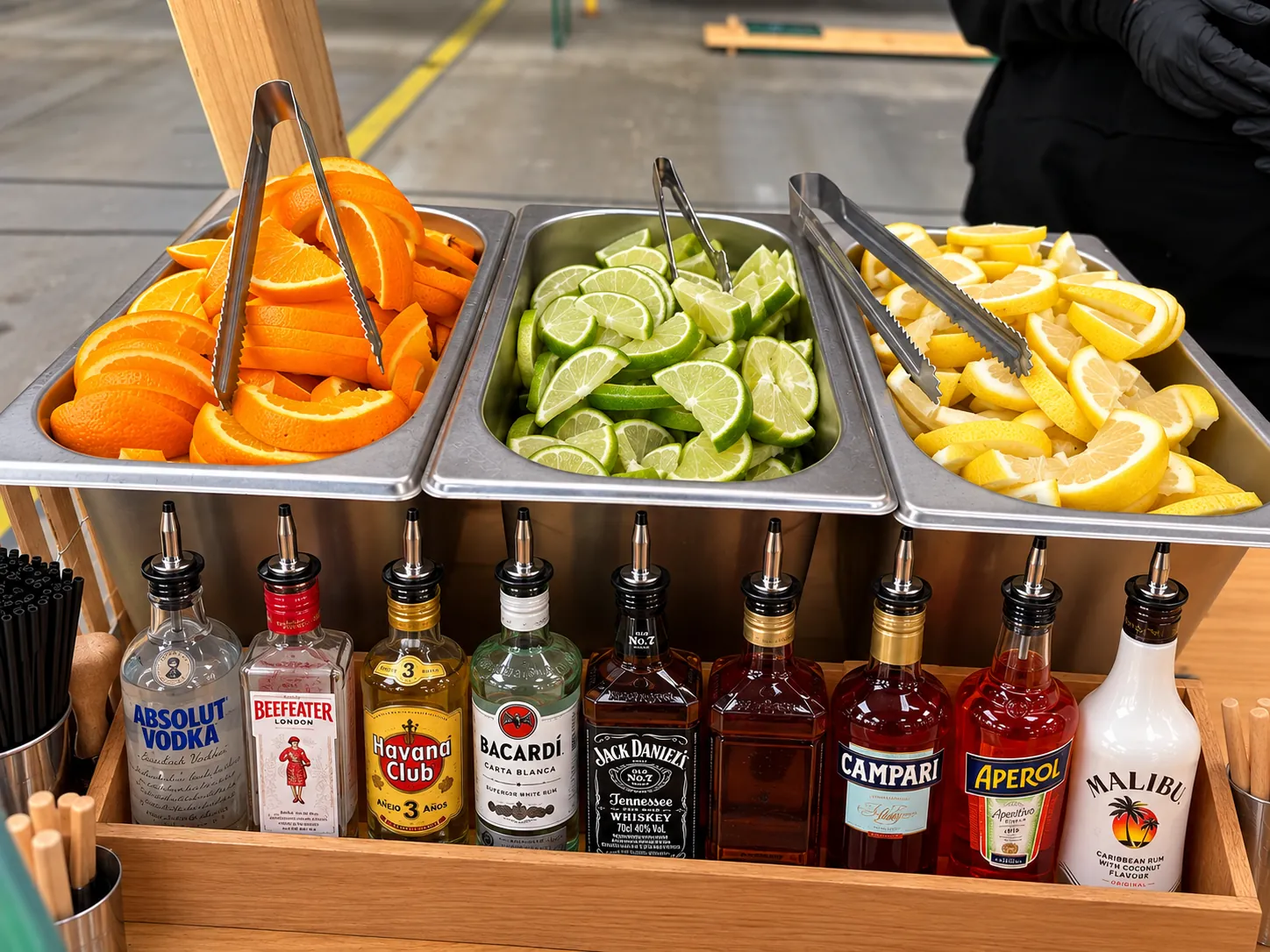 Cocktailbar-Station mit Spirituosen, Orangen, Limetten und Zitronen