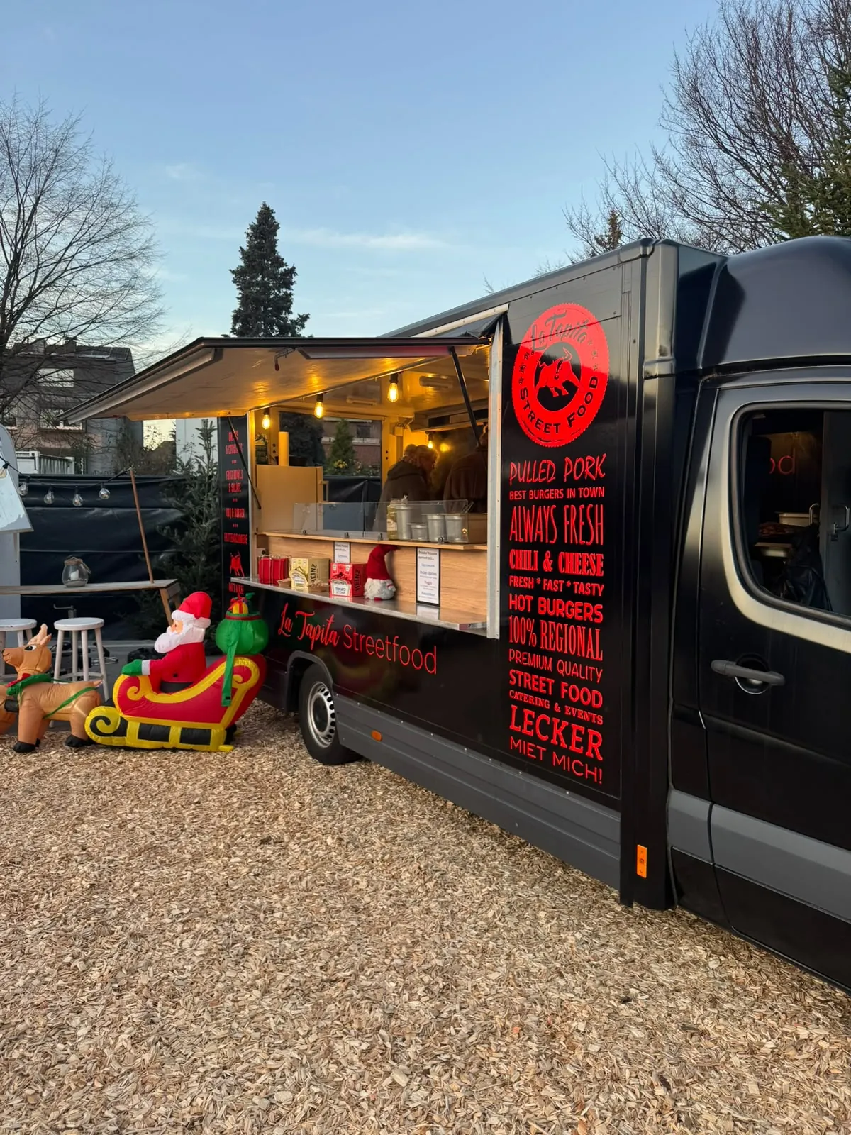 Schwarzer La Tapita Foodtruck auf dem Weihnachtsmarkt mit Santa-Deko