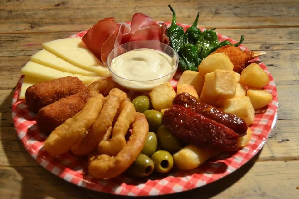 Tapas-Teller mit Serrano-Schinken, Käse, Calamares, Chorizo, Croquetas und Pimientos