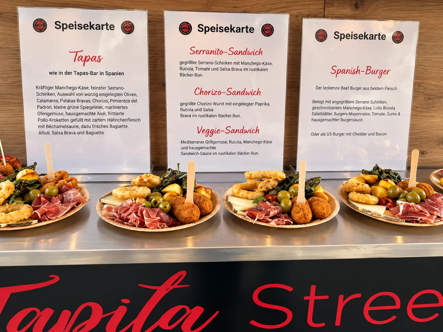 Tapas-Teller vor Speisekarten-Aufstellern an der La Tapita Theke